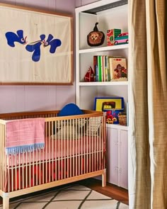 a baby's room with a crib and bookshelf