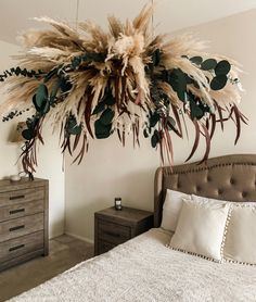 a bedroom with a bed, dresser and plant hanging from the ceiling