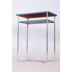 a blue table with two metal legs and a wooden shelf on the top that is shaped like a rectangle