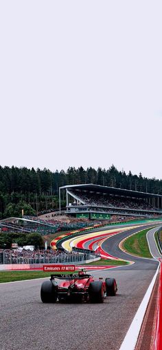 a man driving a red race car down a track