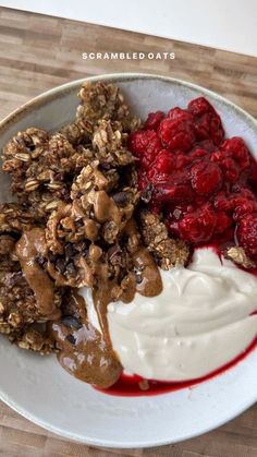 a bowl filled with granola, yogurt and raspberry toppings