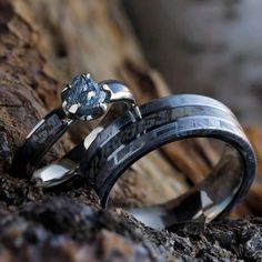 two wedding rings that are sitting on some rocks