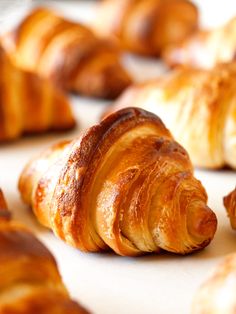 croissants are lined up on a white counter top and ready to be eaten