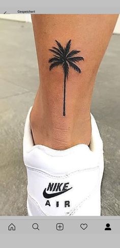 a woman's foot with a palm tree tattoo on the side of her leg