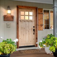 two potted plants sit on the front porch