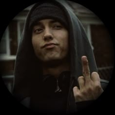 a man in a hoodie making the middle finger sign