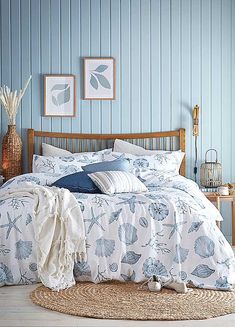 a bedroom with blue walls and white bedding