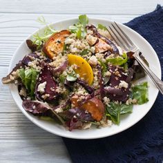 a white plate topped with salad next to a fork