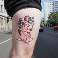 a man with a tattoo on his leg that has a woman's face in the middle