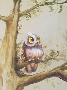 an owl sitting on top of a tree branch in front of a painted wall behind it