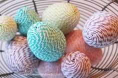 yarn balls are in a basket and being held by someone's hand while knitting them