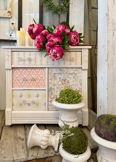 an old dresser with flowers and moss on top