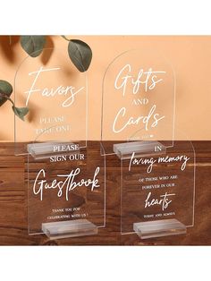 three clear acrylic plaques with the words, gifts and cards on them next to a plant