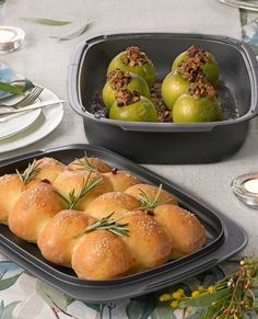 rolls are arranged in trays on a table with plates and silverware around them