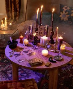 a table topped with candles and pictures on top of a wooden table next to a couch