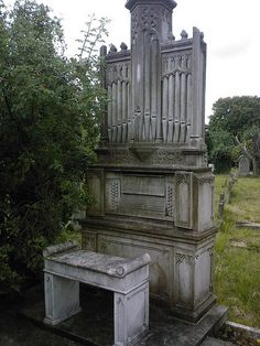 an old pipe organ sitting in the middle of a cemetery