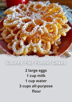 a red plate topped with funnel cakes covered in powdered sugar next to an apple