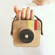 a person holding a wooden camera in their hand