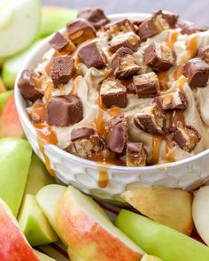 an apple dessert with caramel and marshmallows in a bowl next to sliced apples