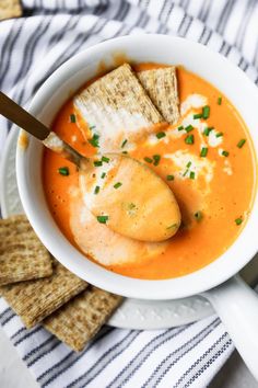 a white bowl filled with soup and crackers