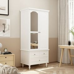 a white cabinet sitting in the corner of a room next to a bed and desk