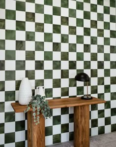 a green and white checkered wall with a wooden table