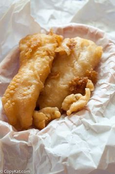 two fried food items sitting on top of white paper