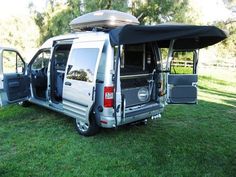 an rv parked in the grass with its doors open