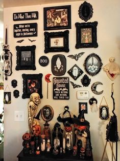 there are many halloween decorations on the wall in this room, including framed pictures and pumpkins