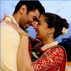 a man and woman embracing each other with the sky in the background