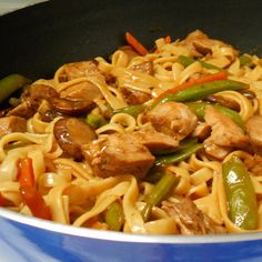 some noodles with meat and green peppers in a pan on the stove, ready to be eaten