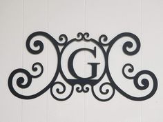 the letter g is made out of metal and has swirly designs on it's sides