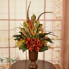 a vase filled with flowers sitting on top of a wooden table next to a window