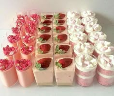 there are many desserts and cups on the table with strawberries in each cup