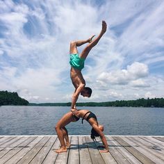 two people are doing yoga on a dock