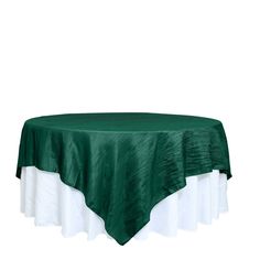 a green table cloth with white ruffled edges on a round tablecloth that is draped over it