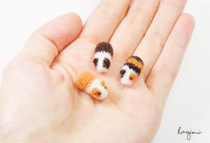 three tiny crocheted animals are sitting in the palm of someone's hand