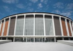 a large round building with many windows on the front and side walls, against a blue sky