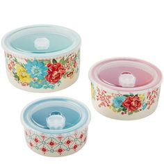 three flowered dishes with lids are shown on a white background and one has a blue lid