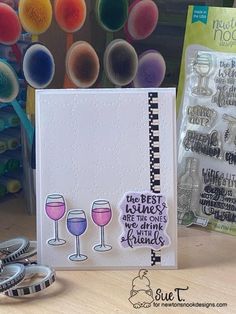 a card with wine glasses on it and some other crafting supplies next to it