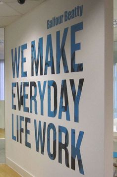 an office wall with the words we make everyday life work on it's side