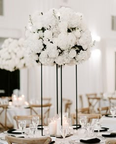 tall centerpieces with white flowers and candles are the focal point for this elegant wedding reception