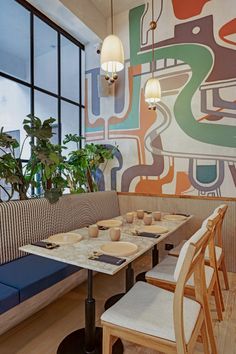 a restaurant with colorful wallpaper and wooden tables