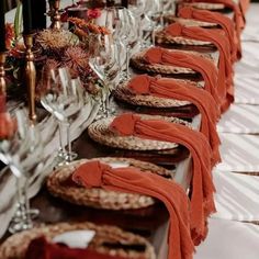 a long table is set with wine glasses and plates