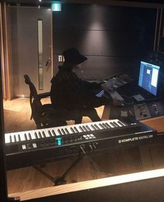 a man sitting at a keyboard in front of a monitor