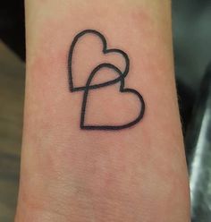 a small heart tattoo on the wrist