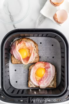 two pieces of bread with eggs on them in a toaster pan next to an egg yolk