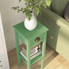 a green end table with a white vase on top