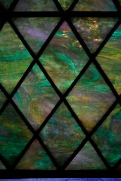 a stained glass window with an abstract pattern in green and purple colors on the outside