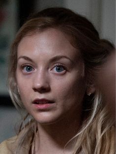 a close up of a person with long hair and blue eyes looking at the camera